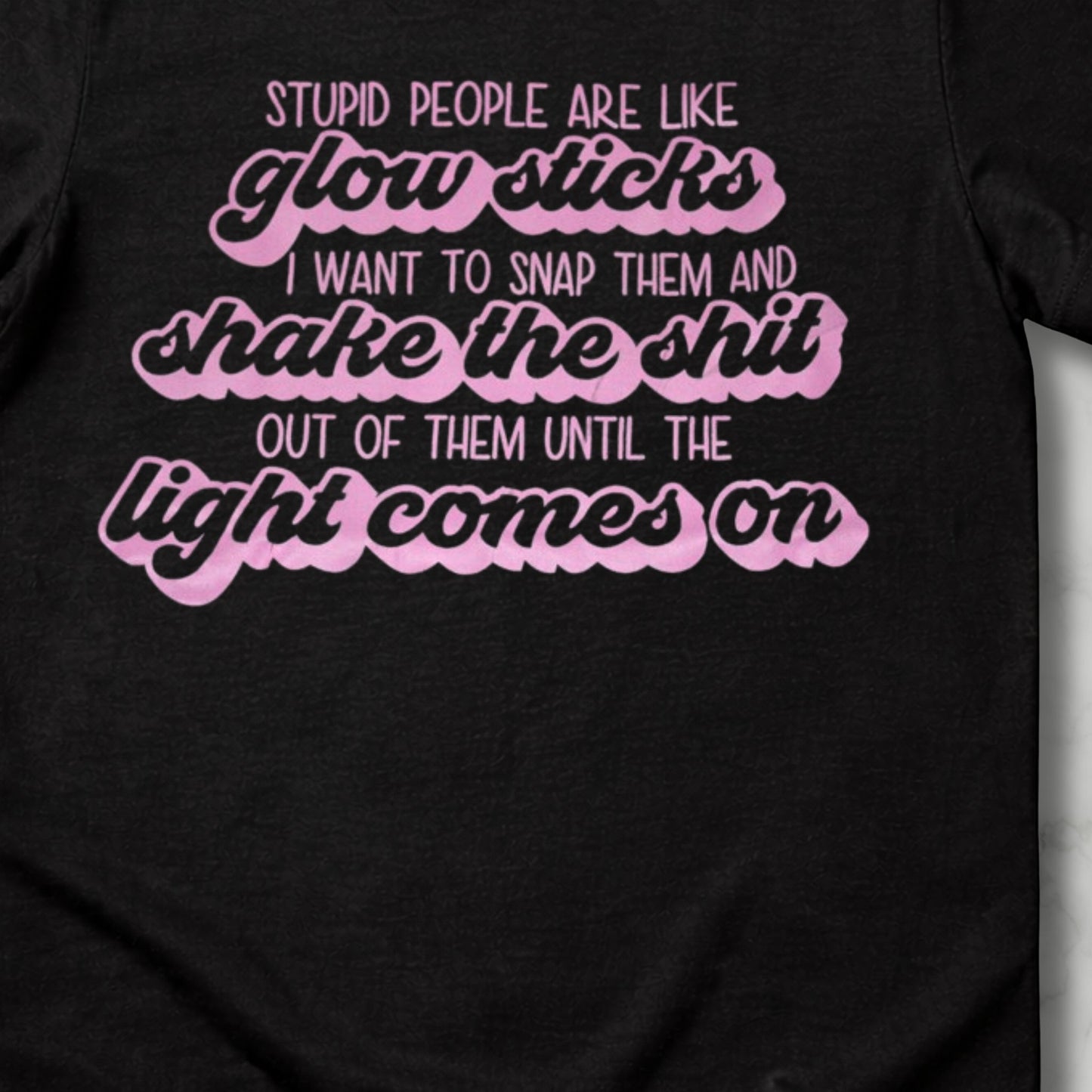 Black t-shirt with pink and white text on a plain background this is heavy discounted t due to black lines on some of the letters 